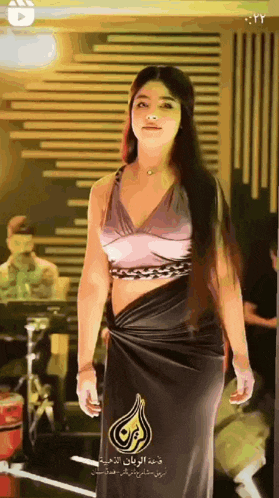 a woman in a black dress with arabic writing on the bottom