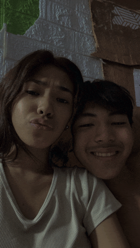 a man and a woman are posing for a picture and the woman is making a funny face