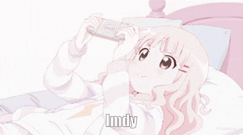 a girl is laying on a bed playing a video game and the word imdy is on the bottom