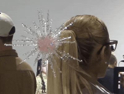 a woman wearing a ponytail with a star shaped accessory in her hair