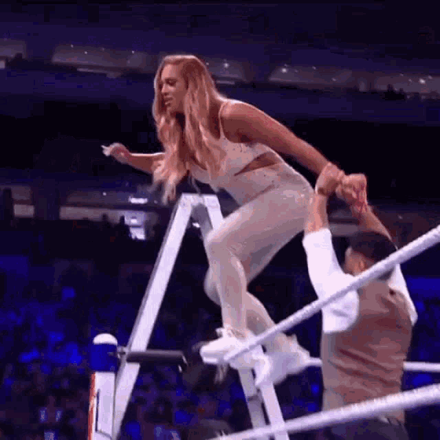 a woman is being helped up a ladder by a man .