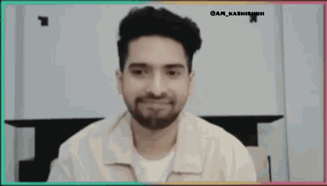 a man with a beard is wearing a white shirt and making a funny face .
