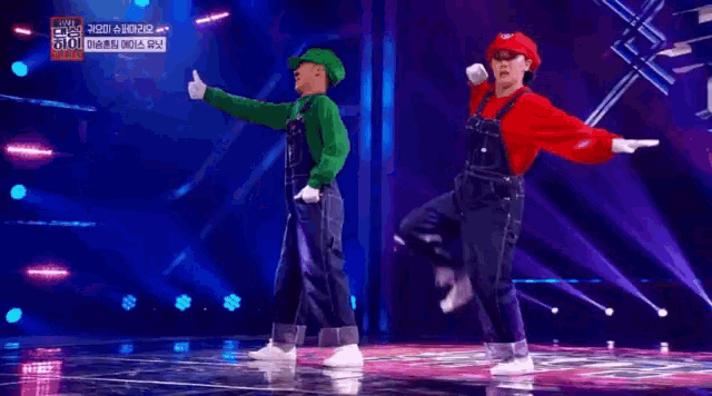 two people are dancing on a stage dressed as mario and luigi