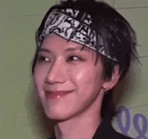 a close up of a person wearing a bandana on their head and smiling .
