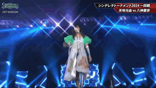 a woman in a white dress is giving a thumbs up in front of a microphone and a sign that says #stardom