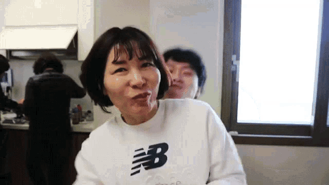 a woman wearing a new balance sweatshirt makes a funny face