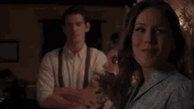 a man and a woman are standing next to each other in a dark room .
