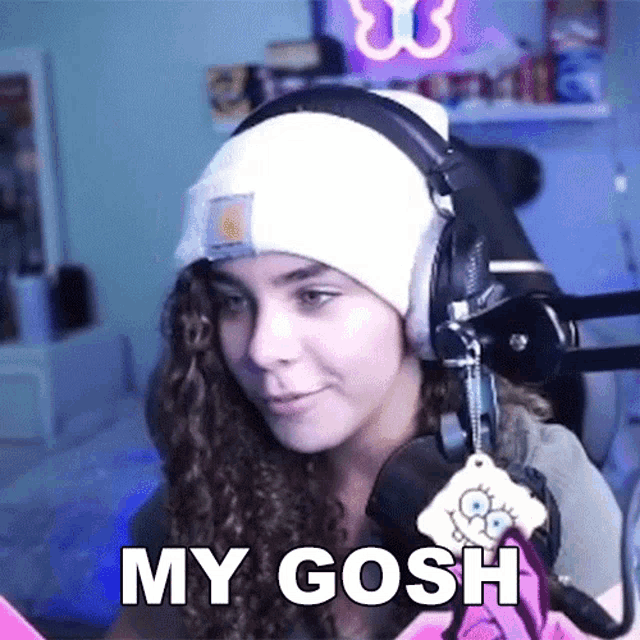 a girl wearing headphones and a beanie says " my gosh "