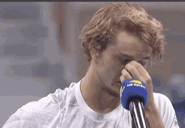 a man wearing a us open microphone covers his nose