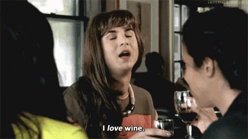 a woman is drinking a glass of wine and saying i love wine .