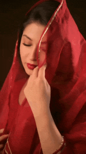 a woman covering her face with a red cloth
