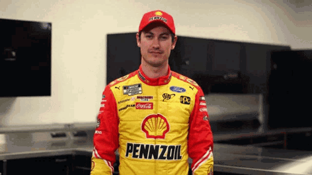 a man wearing a pennzoil jacket stands in a room