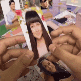 a person is holding a picture of a woman 's face in their hands .