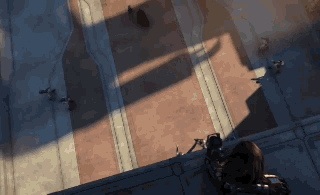 a group of people are standing on a balcony looking down at something .