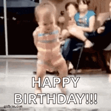 a baby is dancing in a room with the words `` happy birthday '' written on it .