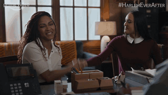 two women are sitting at a desk with a phone in front of them and the words harlem ever after on the bottom