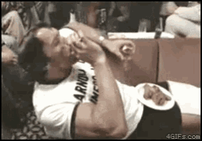arnold schwarzenegger is laying on the floor with a plate of food