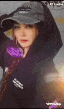 a woman wearing a hat and a hoodie is standing in front of a camera .