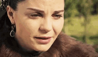 a close up of a woman 's face with tears coming down her face .