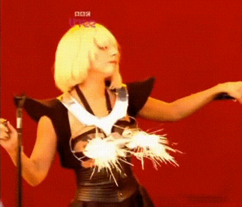 a woman is standing in front of a microphone with a bbc logo on her head