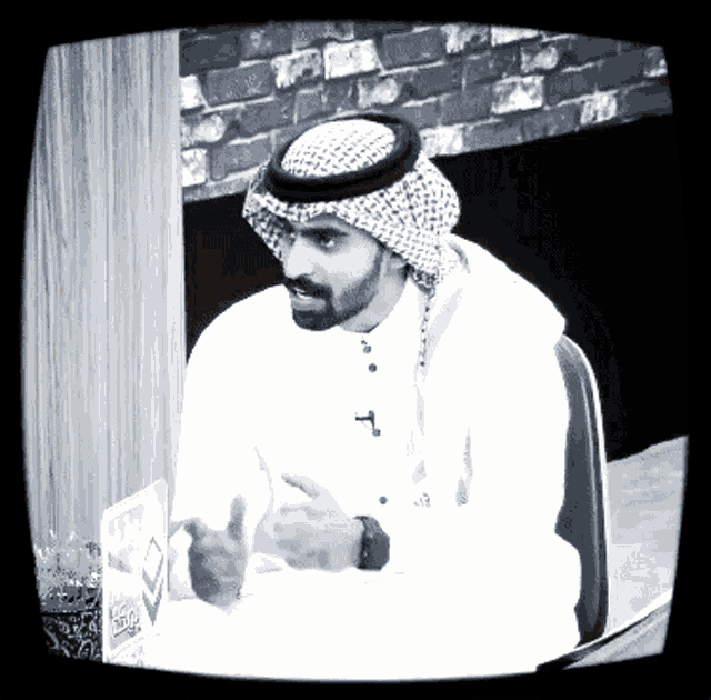 a black and white photo of a man wearing a turban and a watch