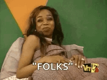 a woman is laying on a bed with the words `` folks '' written on it .
