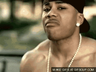 a shirtless man wearing a baseball cap and pearls looks at the camera ..