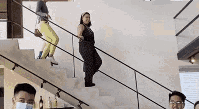 a group of people are standing on a set of stairs wearing face masks .