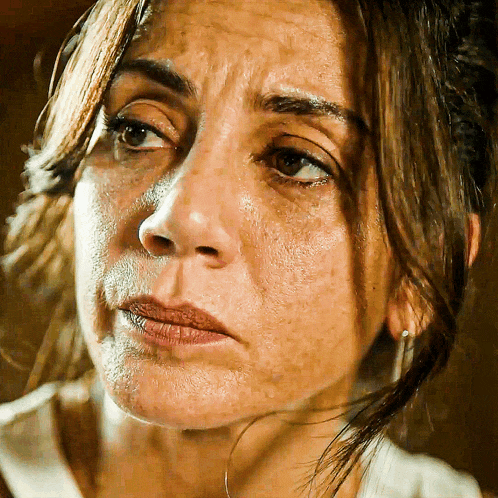 a close up of a woman 's face with a sad expression