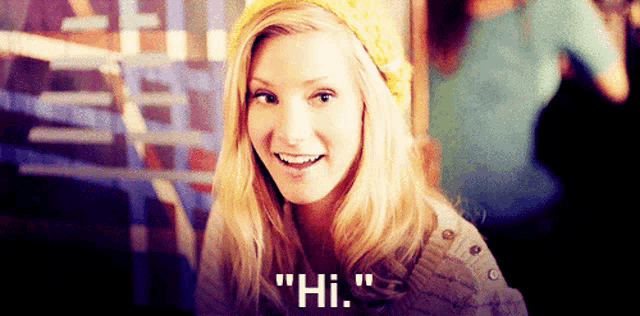a woman in a yellow hat is smiling and says " hi "