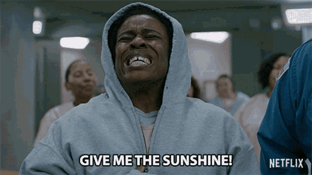 a woman in a hooded sweatshirt is crying and says give me the sunshine