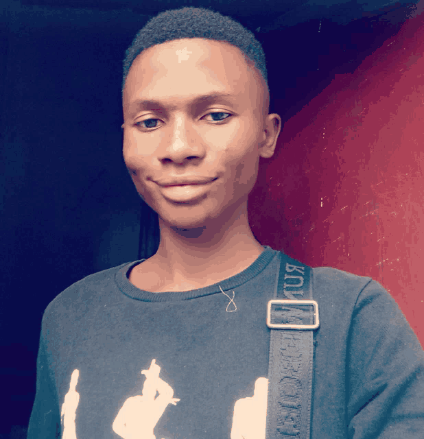 a young man wearing a black shirt and a black strap that says ' km ' on it