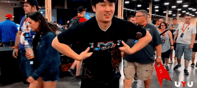a man in a black shirt is dancing in a crowd .