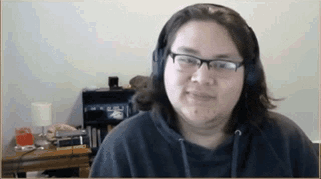 a woman wearing glasses and headphones is smiling for the camera