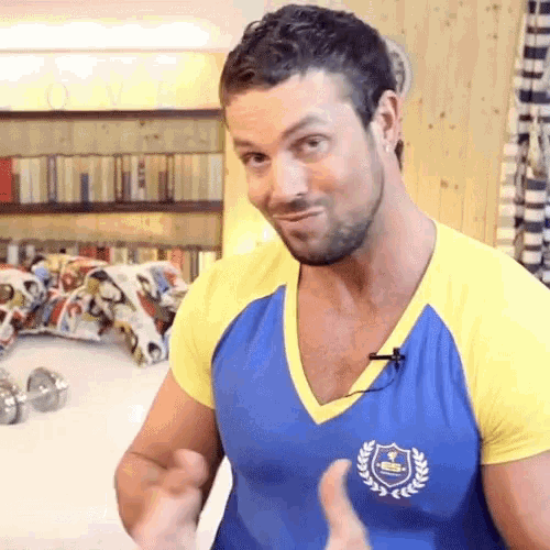 a man wearing a blue and yellow t-shirt with a shield on it