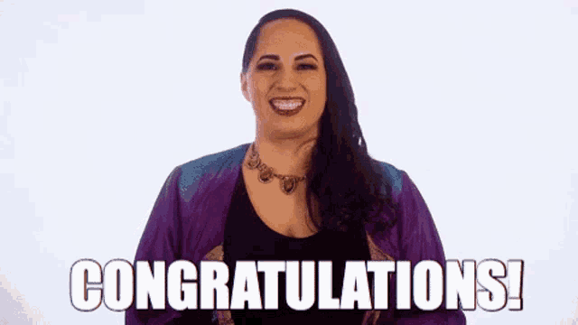 a woman is holding her hands in the air and saying congratulations !
