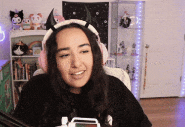 a woman wearing a headband with horns on it is smiling