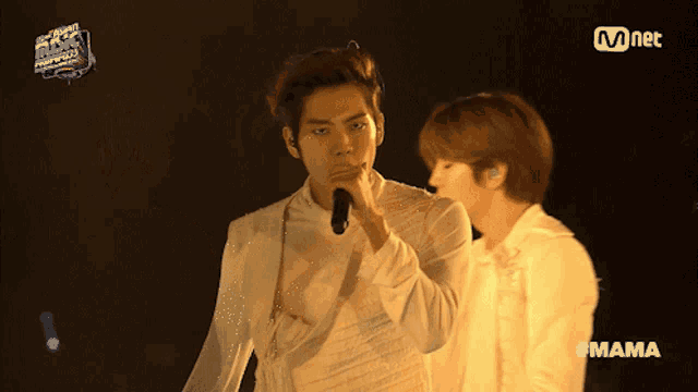 two men singing on a stage with the hashtag mama
