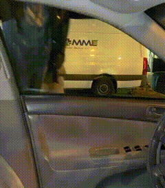 a white van with mme written on the side is parked in front of a car