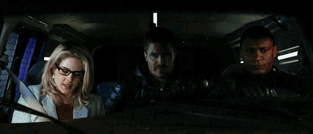 a group of people are sitting in a car and one of them has glasses on