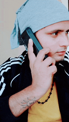 a man with a tattoo on his arm talking on a phone