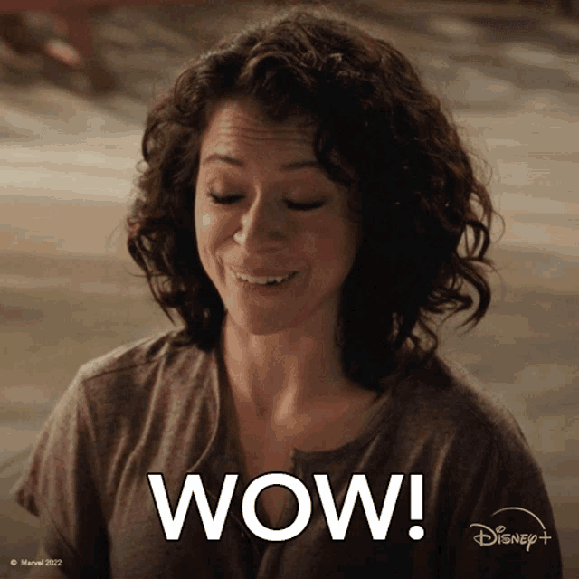 a woman with curly hair says wow in a disney+ advertisement
