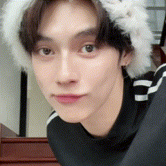 a close up of a man wearing a fur hat and a black sweater .