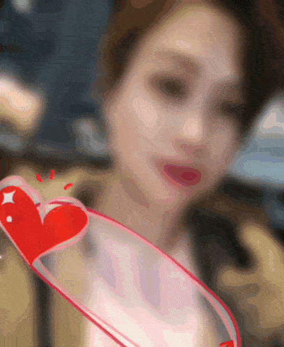 a blurry picture of a woman with a red heart in front of her