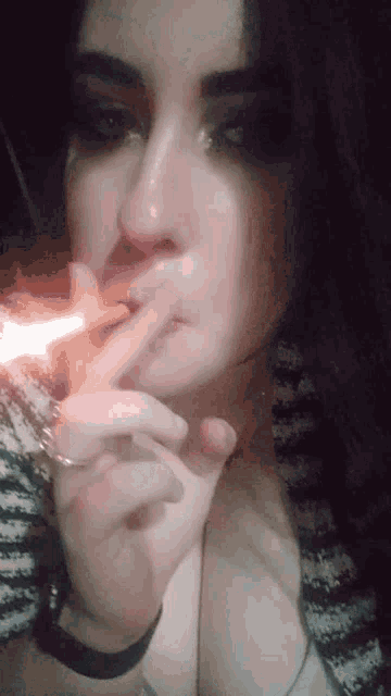 a woman is smoking a cigarette with a lighter in her hand