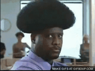 a man in a purple shirt has an afro on his head