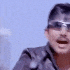 a man wearing sunglasses is standing in front of a blue sky and making a funny face .