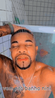 a shirtless man with a beard is taking a selfie in a bathtub .