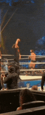 a wrestling match is going on in a ring with a w logo on the side