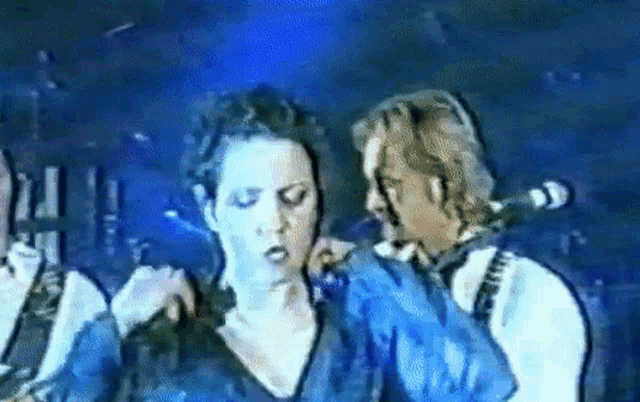 a man and a woman are standing next to each other on stage .